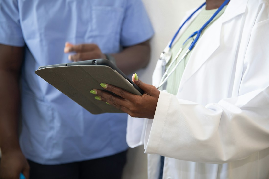 Healthcare professional explaining information on a tablet during a consultation