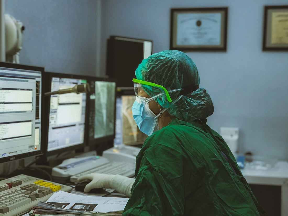 Healthcare professional working with digital systems in a hospital control room