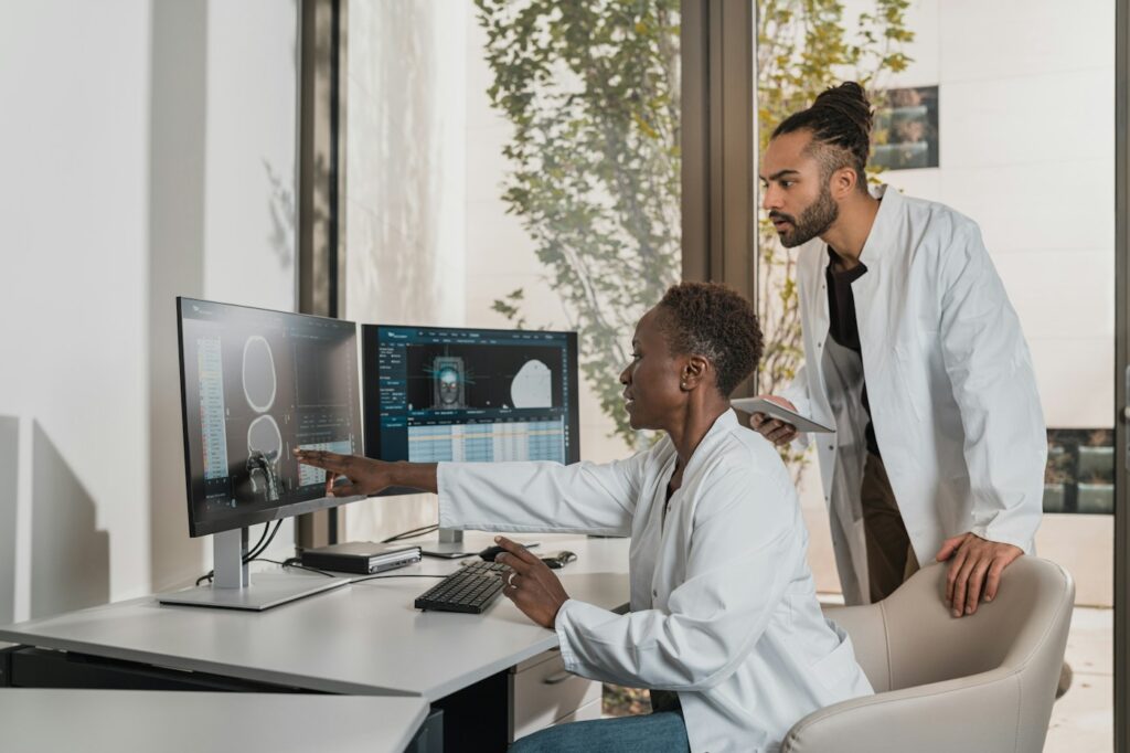 Medical professionals reviewing clinical information on computer monitors