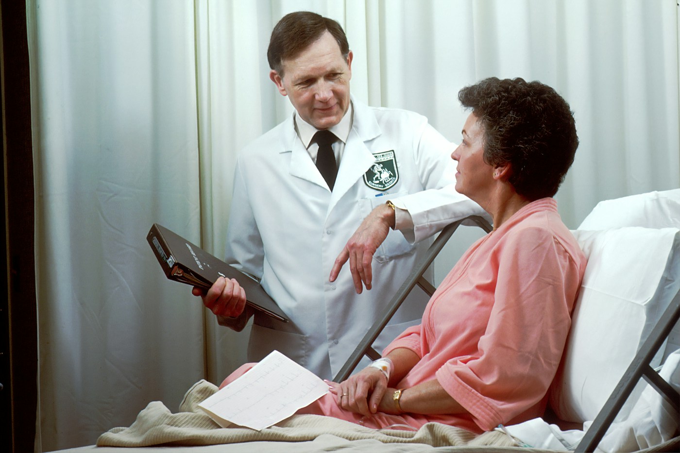 Doctor speaking with a patient beside a hospital bed